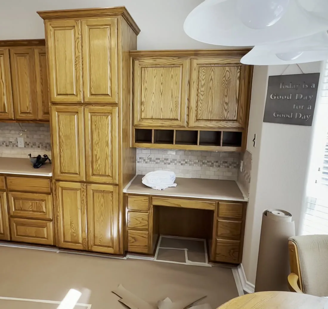 The kitchen on March 10, 2025, with oak cabinets taped off for painting